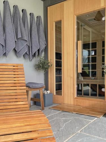 a porch with a wooden bench next to a door at The Hideaway Retreat in Omagh