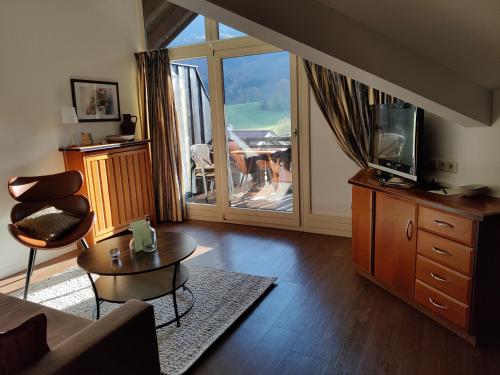 a living room with a couch and a tv and a table at Gasthof Fischerstüberl in Rottau