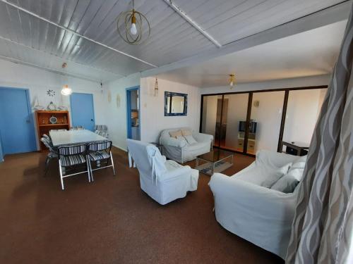 una sala de estar con sofás blancos y una mesa. en Casa Bahía Inglesa, en Bahía Inglesa