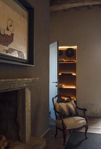 a living room with a chair and a fireplace at Rastrello in Panicale
