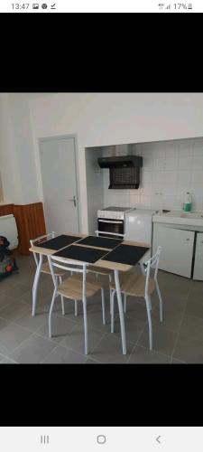 - une cuisine avec une table et deux chaises dans l'établissement En pleine montagne T1 30m2 parking à coté, à Amplaing