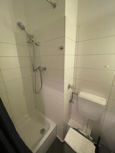 a white bathroom with a shower and a toilet at 1 Zimmer Wohnung in Strand nähe in Kiel