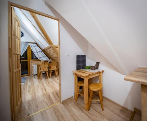 a small table and stool in a room with an attic at Pokoje Małgorzatka in Zakopane
