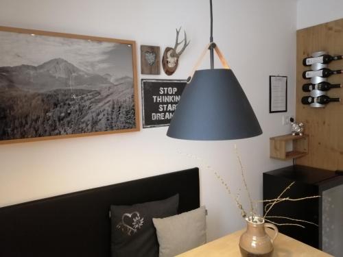 a lamp hanging over a table in a room at Huber - Das Tiroler B&B in Oberperfuss