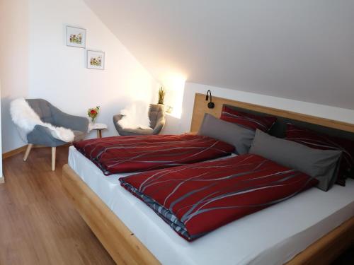 a bedroom with a bed with a red comforter at Pension zum Bären in Langerringen