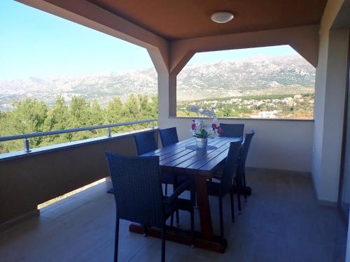 a dining room with a table and chairs on a balcony at APARTMAN DANE in Rovanjska