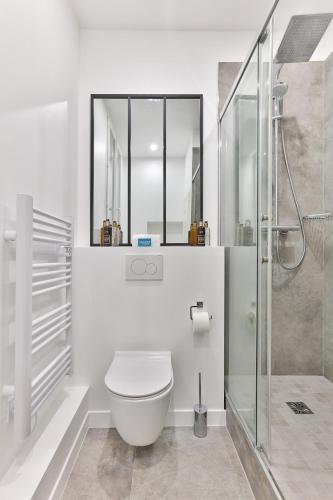 une salle de bain blanche avec toilettes et douche dans l'établissement 126 - Urban Amazing 3BR Montorgueil, à Paris