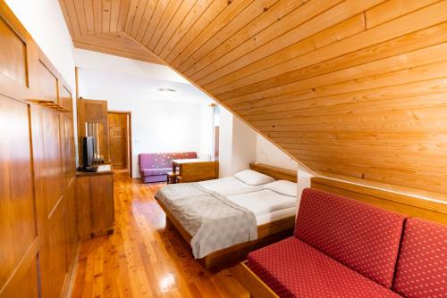 Zimmer mit einem Bett und einem roten Sofa in der Unterkunft Govc-Vršnik in Solčava