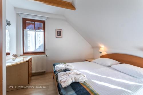 1 dormitorio con cama, lavabo y ventana en Apartmaji Potepuh, en Kranjska Gora