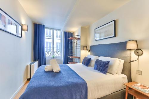 une chambre avec un grand lit avec une couverture bleue dans l'établissement 131 - Urban Brand New 110m2 Beautiful Flat in Montorgueil, à Paris