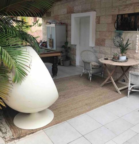 a large white vase next to a table and chairs at Risan Chill in Eilat