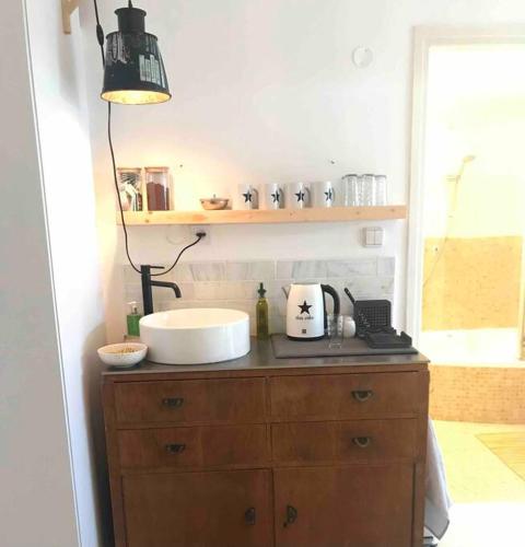 a bathroom with a counter with a sink and a lamp at Risan Chill in Eilat