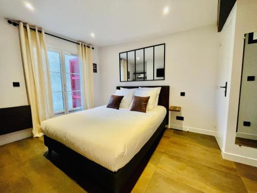 une chambre avec un lit et une grande fenêtre dans l'établissement L'Atelier des bords de l'Eure, à Chartres