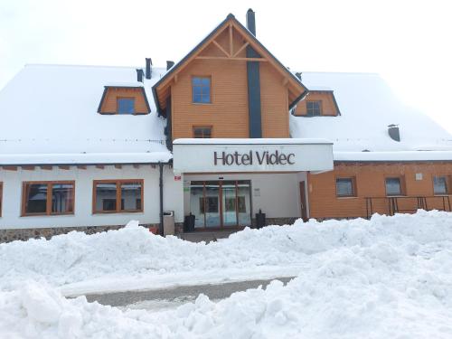 a building with lots of snow in front of it at Pohorje Village Wellbeing Resort - Forest Hotel Videc in Pohorje