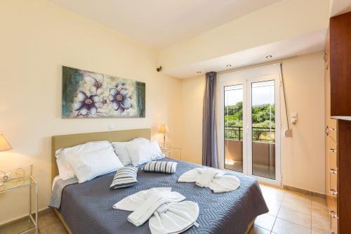 ein Schlafzimmer mit einem Bett mit zwei Handtüchern darauf in der Unterkunft Villa Lambros in Roústika