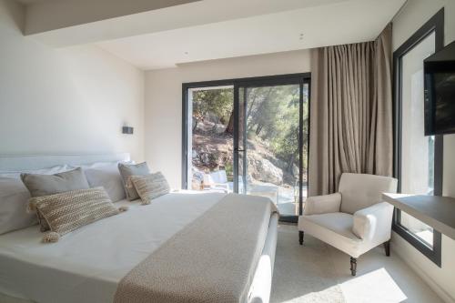 a bedroom with a large white bed and a chair at Villa Vista Mare by iVillamia com in Villefranche-sur-Mer