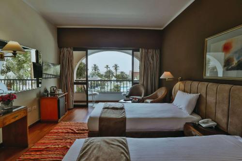 Cette chambre comprend deux lits et une grande fenêtre. dans l'établissement Basma Hotel Aswan, à Assouan