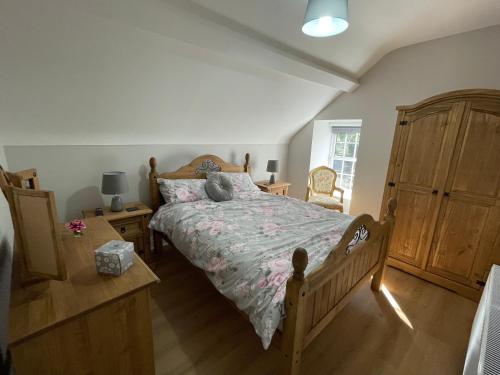 um quarto com uma cama e uma cómoda em madeira em Rose Cottage em Cullybackey