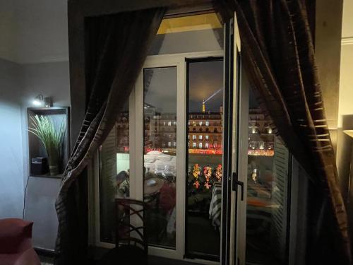 - une fenêtre avec vue sur la ville la nuit dans l'établissement Élysées vip, à Paris