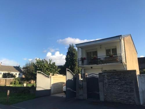 a white house with a gate and a balcony at la Rose sur Meuse in Haybes