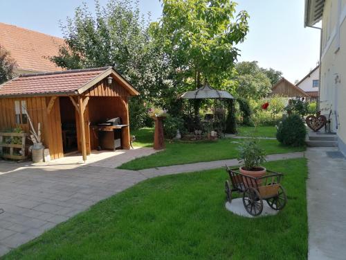 een tuin met een prieel en een kar in het gras bij Pension zum Bären in Langerringen