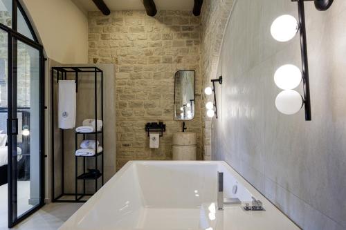 a bathroom with a large tub and a stone wall at Villa Lygia in Petres