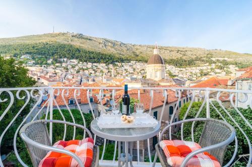 a balcony with a table and chairs and a bottle of wine at Rooms Vlaho in Dubrovnik