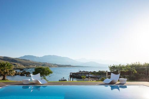 a swimming pool with chairs and a view of the water at Villa Lygia in Petres
