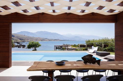 a living area with a table and chairs and a pool at Villa Lygia in Petres