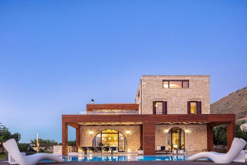 a large brick house with a pool in front of it at Villa Lygia in Petres