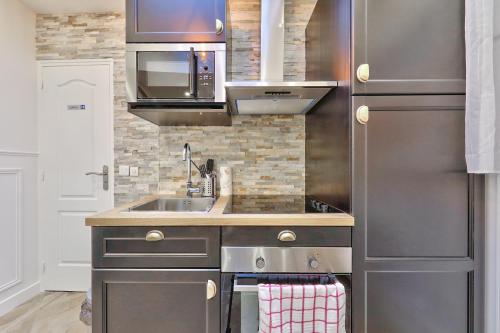 une cuisine avec un évier et un micro-ondes dans l'établissement 38 Atelier Mona Lisa, à Paris