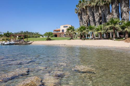 a view of a beach with palm trees and a building at Villa Lygia in Petres