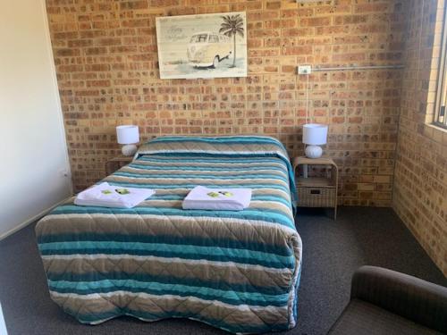 a bedroom with a bed with towels on it at Golden Beach Motor Inn in Caloundra