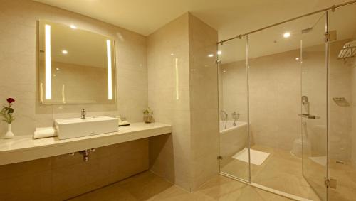 a bathroom with a sink and a shower at Goutham Grand Hotel in Tenāli