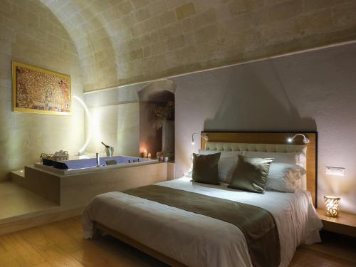 a bedroom with a large bed and a bath tub at SaxAurea in Matera