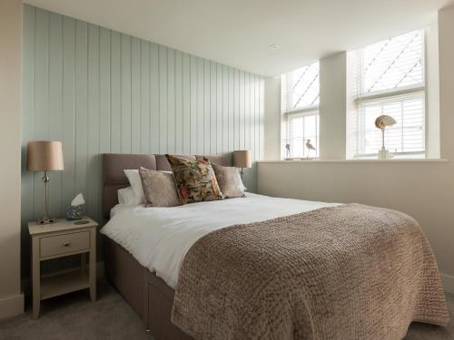 une chambre avec un grand lit et deux fenêtres dans l'établissement Church Rooms, à Port Isaac