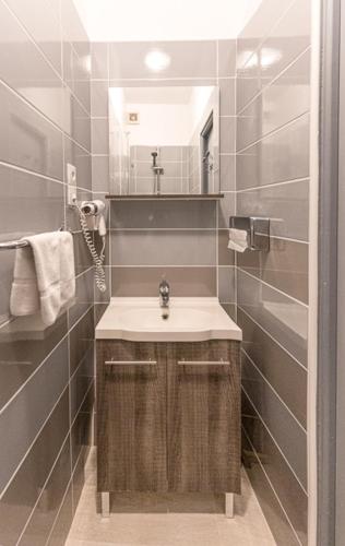 une salle de bain avec un lavabo et un miroir dans l'établissement Au Bien Etre piscine chauffée, à Villecroze