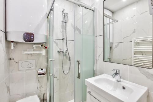 une salle de bain avec une douche, un lavabo et un miroir dans l'établissement Urban Flat 55 - ATELIER MARILYN MONROE, à Paris