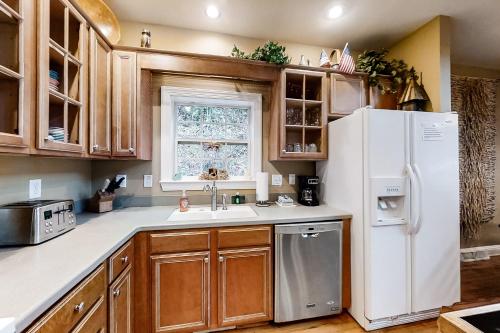 a kitchen with a white refrigerator and a window at Above the River in Sylva