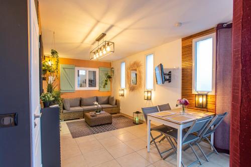 uma sala de estar com uma mesa e cadeiras e um sofá em Superbe appartement - Terrasses - Clim - Parking prépayé em La Valette-du-Var