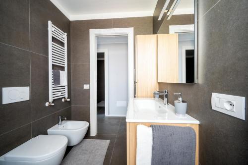 ein Badezimmer mit einem Waschbecken, einem WC und einem Spiegel in der Unterkunft Appartamento Maestrale in Riccione