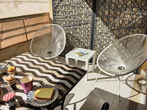 - deux chaises blanches assises sur une terrasse avec une table dans l'établissement Nestor&Jeeves - PALAIS MEDITERRANEE TERRASSE - Central - Very close sea, à Nice
