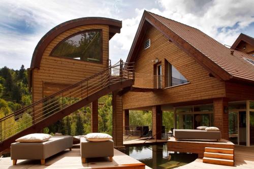a house with a staircase and a pool at LA CHENEAUDIÈRE - Hôtel Spa - Relais & Châteaux - Restaurant étoilé in Colroy-la-Roche