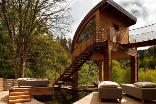 a tree house with a spiral staircase and a deck at LA CHENEAUDIÈRE - Hôtel Spa - Relais & Châteaux - Restaurant étoilé in Colroy-la-Roche