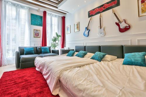 - un grand lit dans une chambre dotée de guitares sur le mur dans l'établissement 68 - The Rolling Stones Flat, à Paris