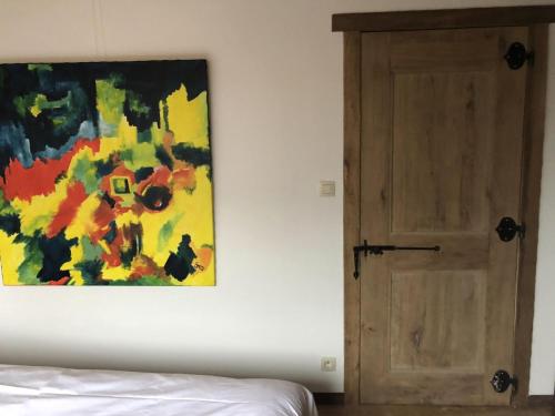 a painting hanging on a wall next to a door at Villa de Poothoeve with Sauna and beautiful garden in Bilzen