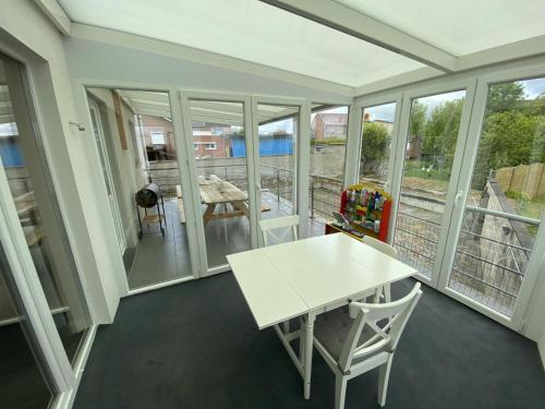 a room with a white table and chairs on a balcony at Cosy vacation home for 8 persons in Heers