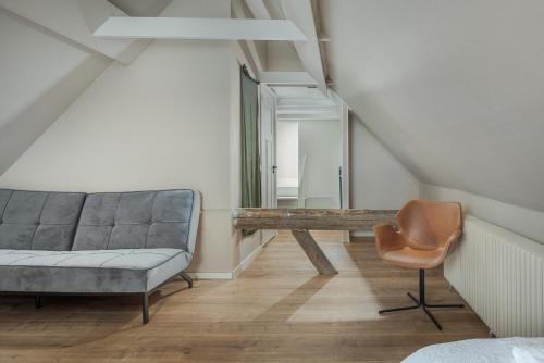 a living room with a couch and a mirror at Large fully renovated farmhouse with indoor Swim spa and Sauna in Lemmer