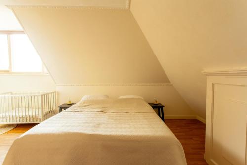 a bedroom with a white bed with two tables at Beautiful American style villa with heated Pool and Jacuzzi in Heerhugowaard