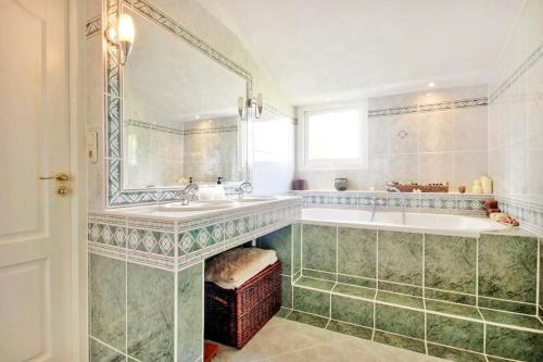 a bathroom with a tub and a large mirror at Beautiful American style villa with heated Pool and Jacuzzi in Heerhugowaard